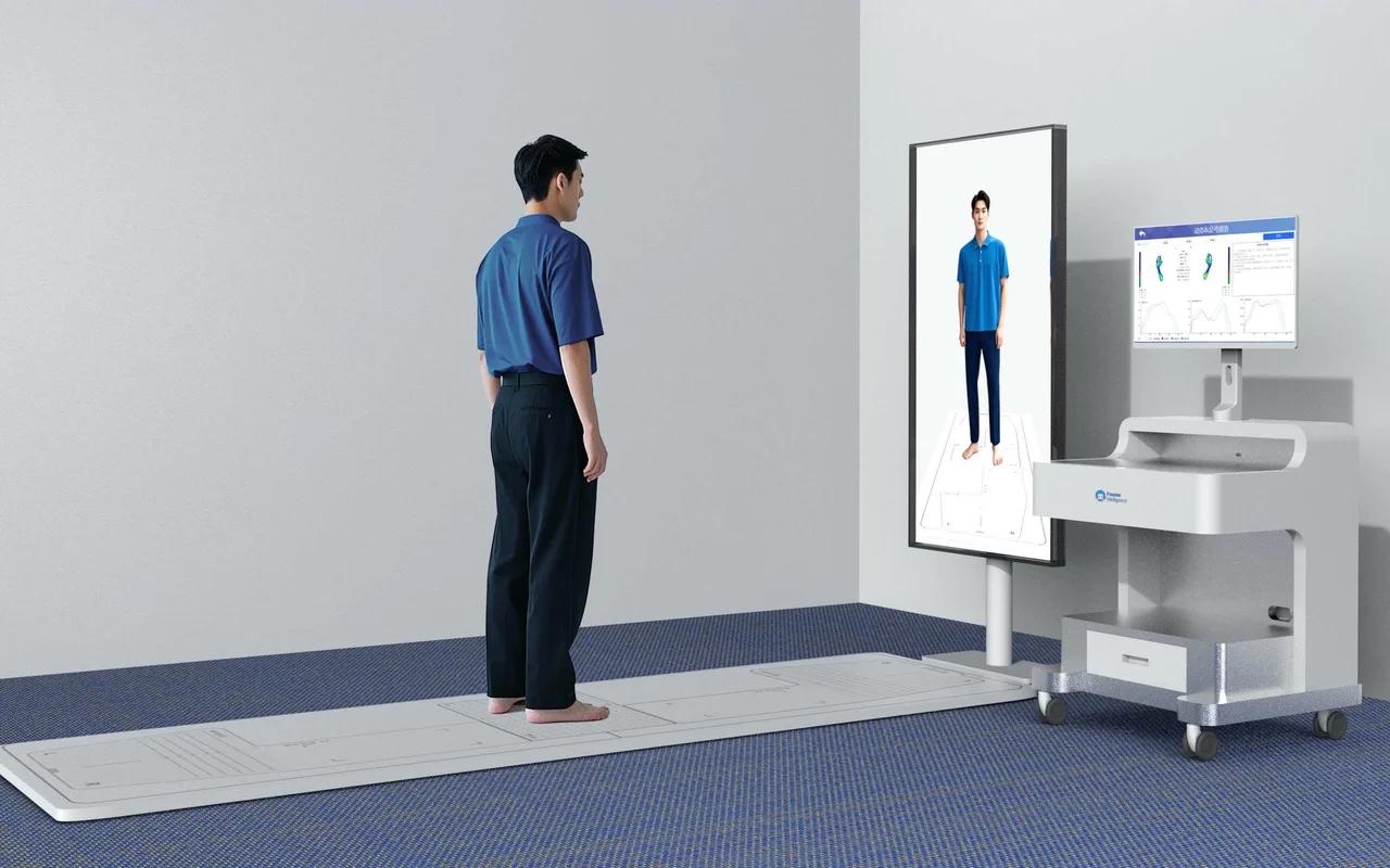 A community hospital assessment room (device rendering): a person stands barefoot on the pressure plate in the middle of the walkway, flanked by wooden walkway boards with foot-position guides, facing a vertical display showing a posture outline and a foot-pressure map, with a white cart workstation and monitor to the right